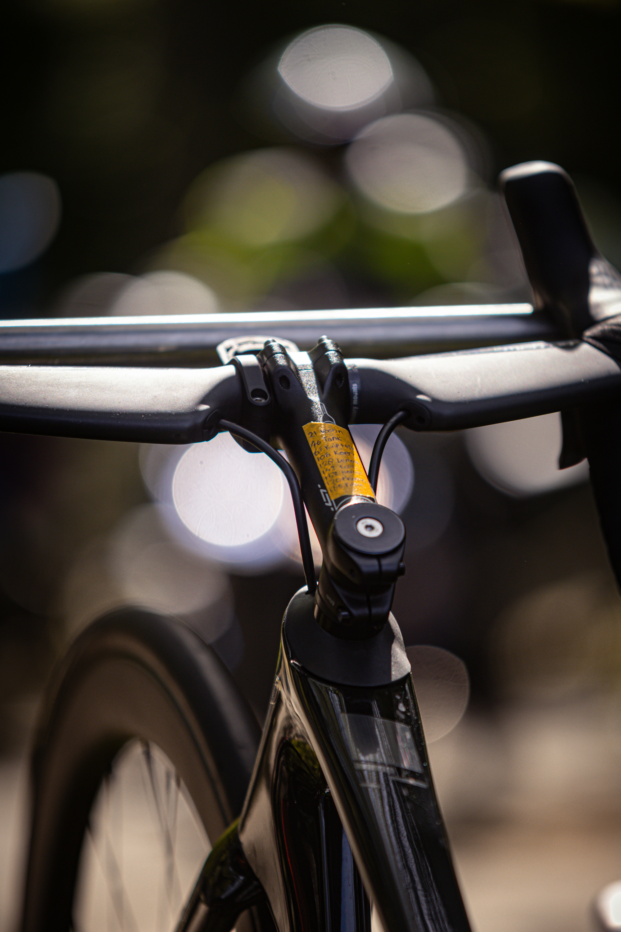 A bicycle with a yellow sticker on the handlebars is being photographed by a professional photographer.