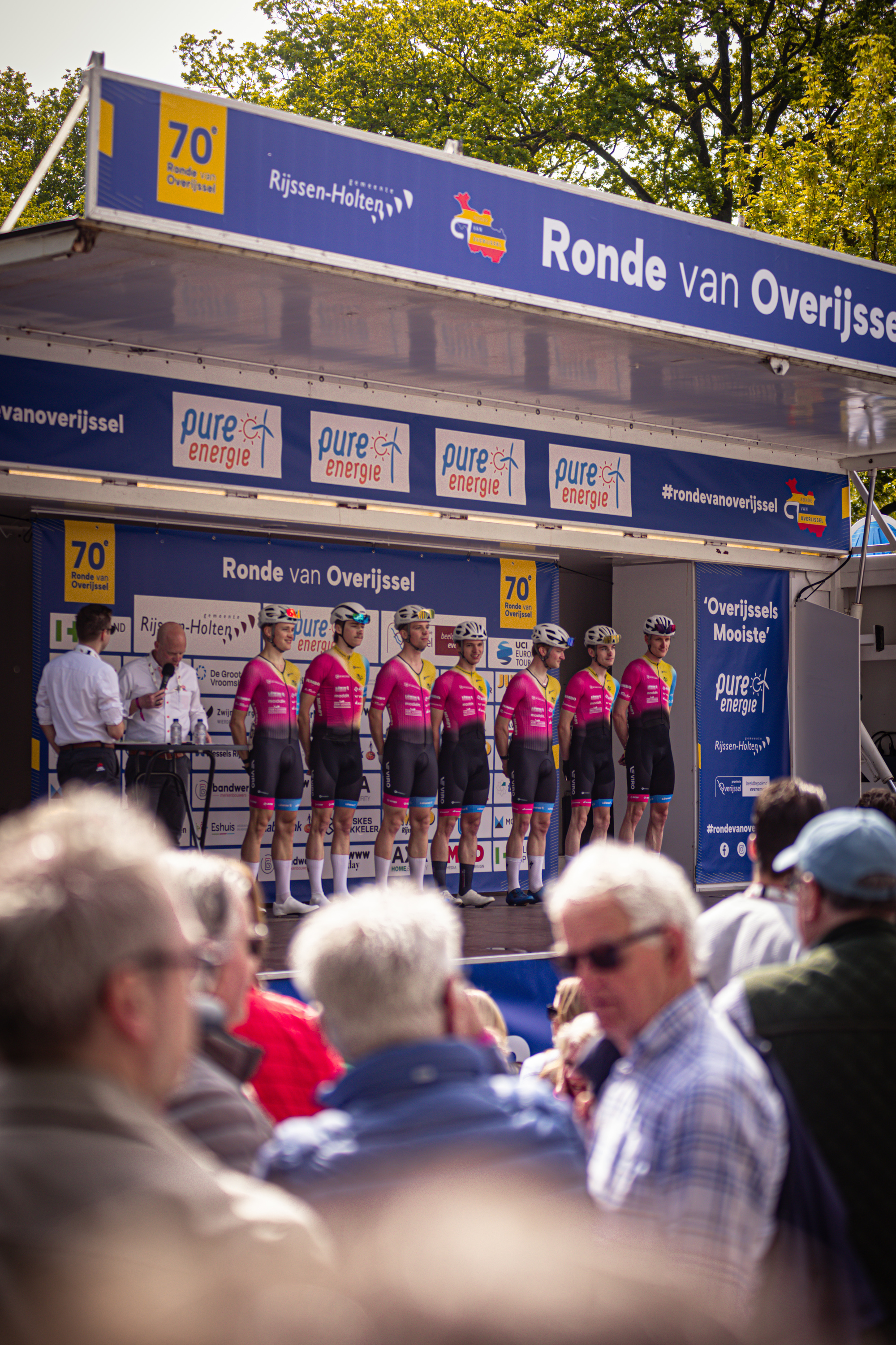 A man and a woman in pink outfits are being crowned the winners of a competition.