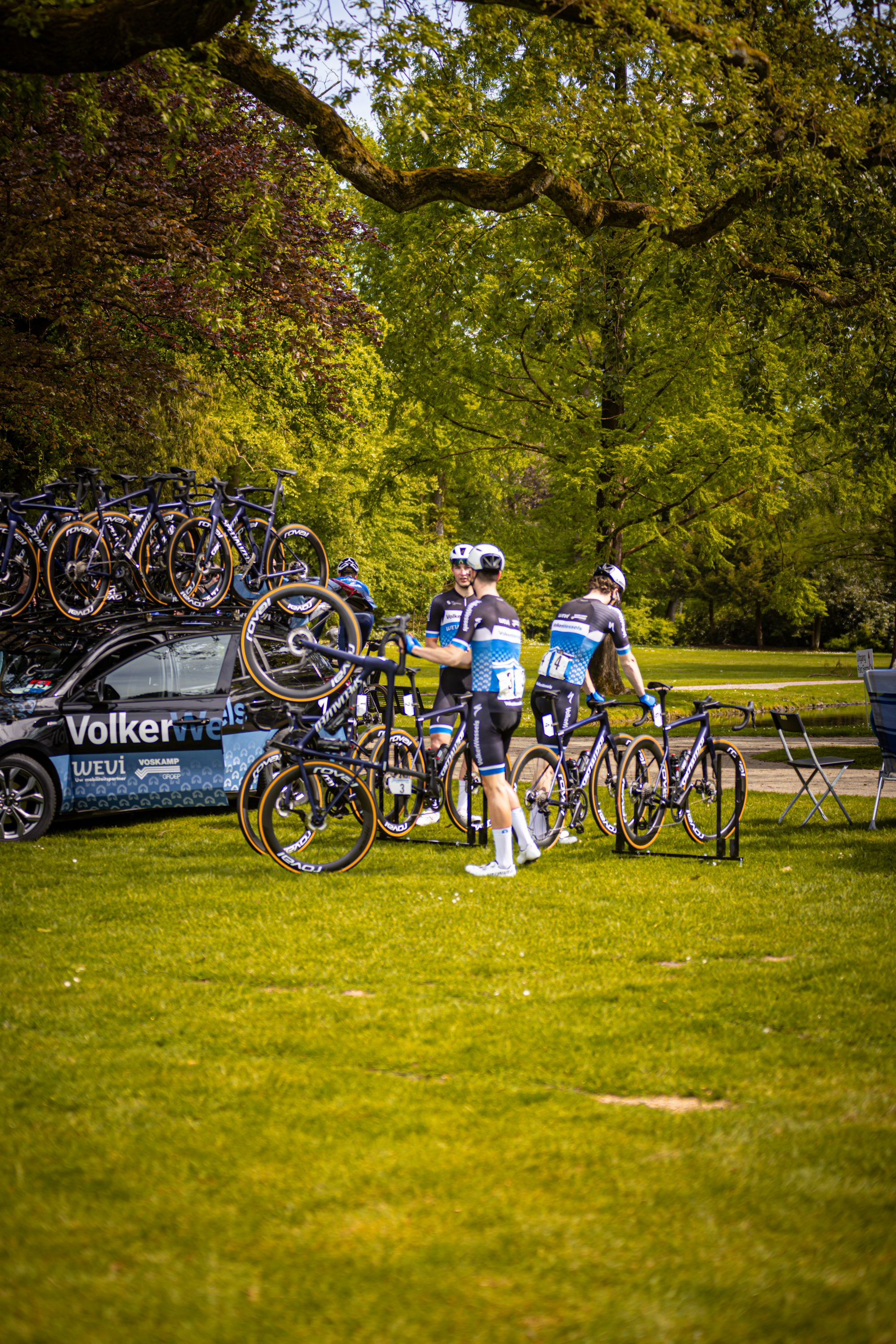 Two people standing in front of a group of bicycles. The person on the left is wearing a blue shirt and has white pants.