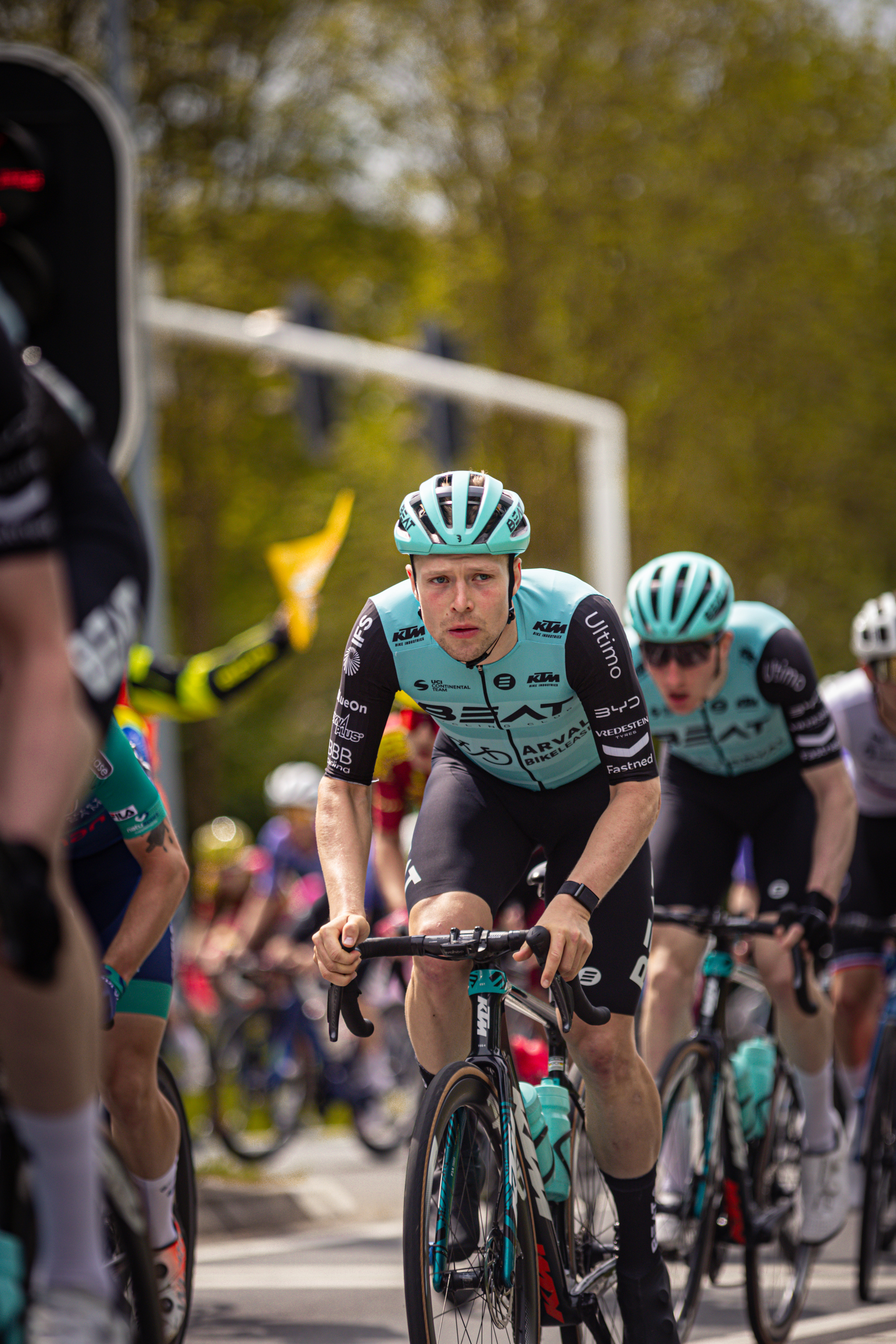 A bicycle race is taking place and the riders have their helmets on.