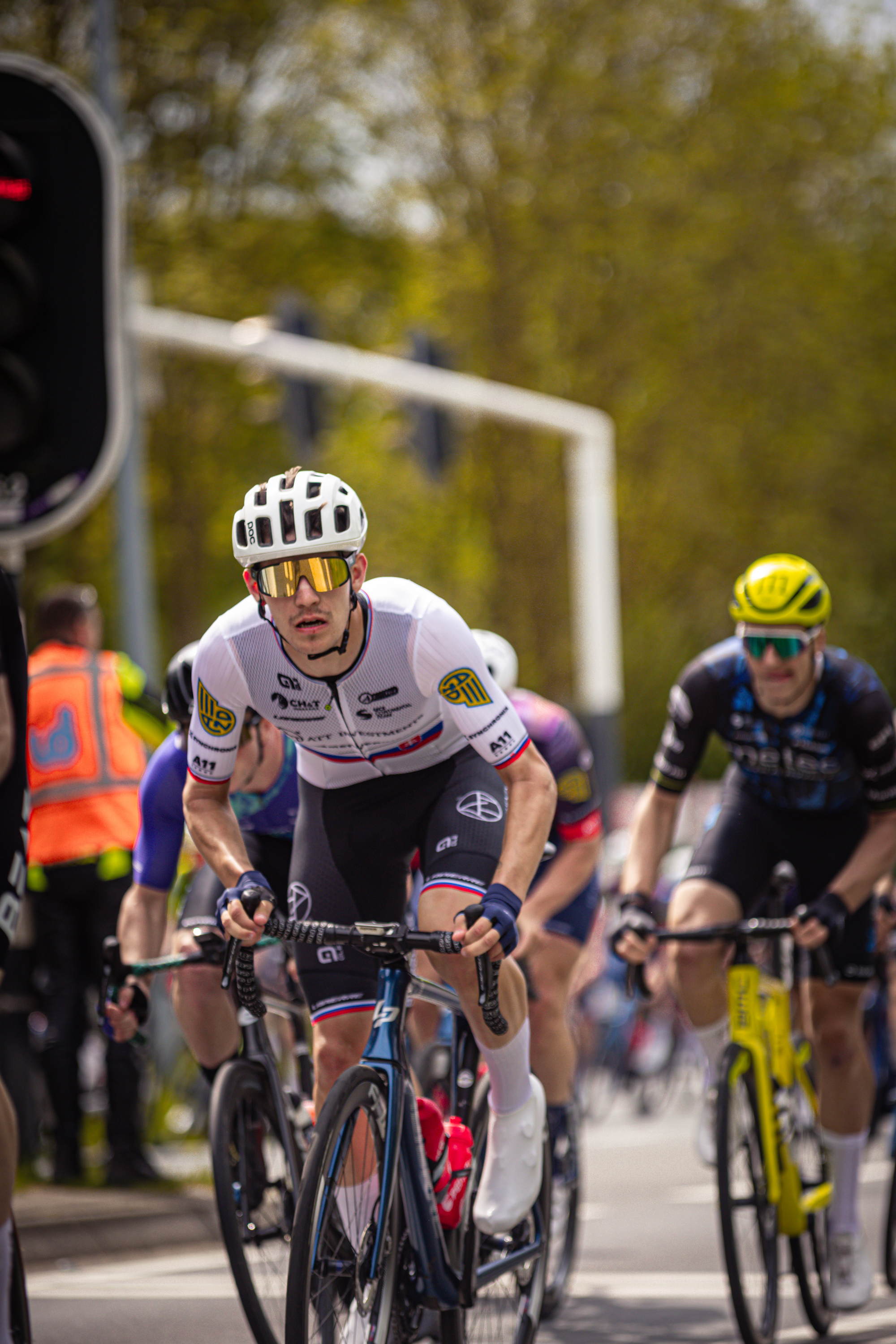 Two cyclists are riding on a street in the Netherlands during a race.