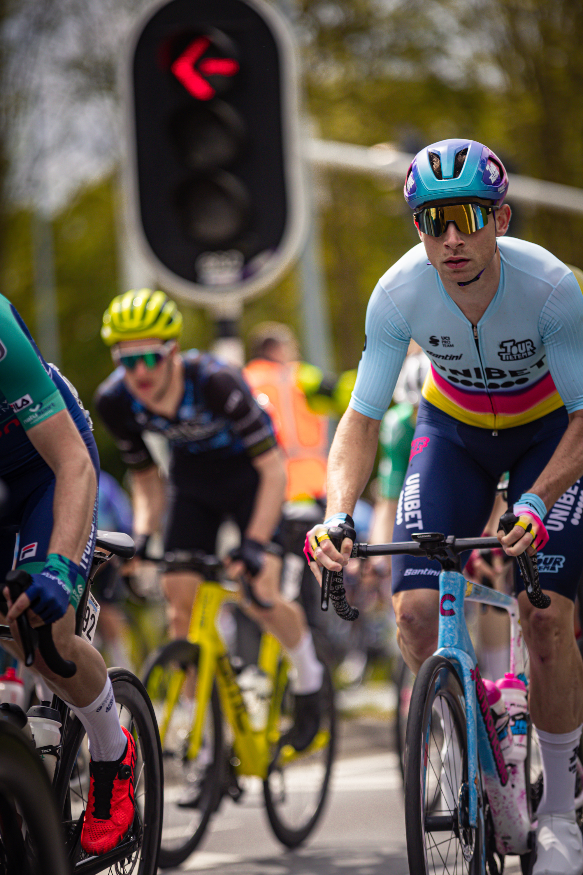 A man riding a bike in a cycling race wearing blue and purple.