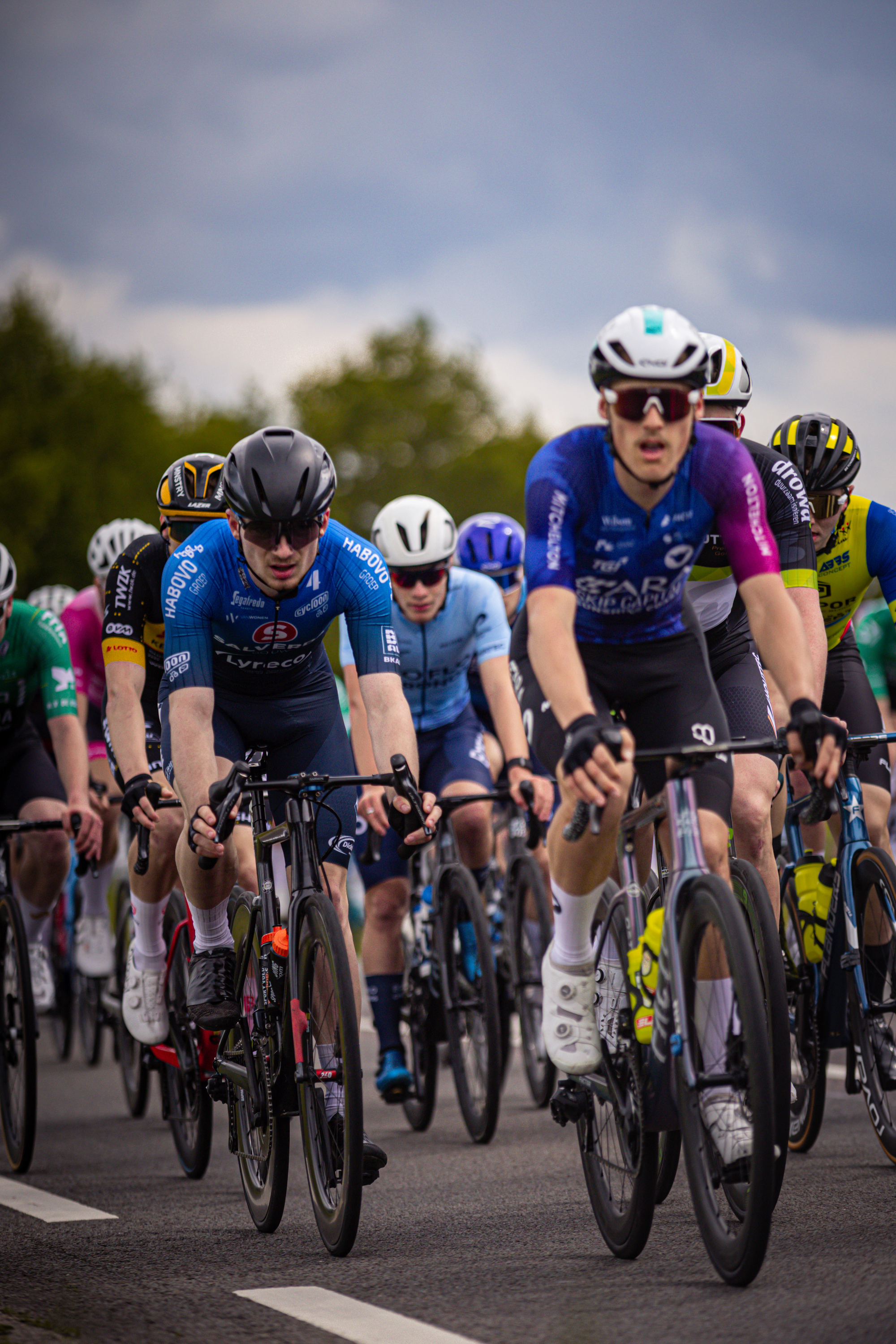 A group of cyclists on a road, with the words Ronde van Overijssel on it.