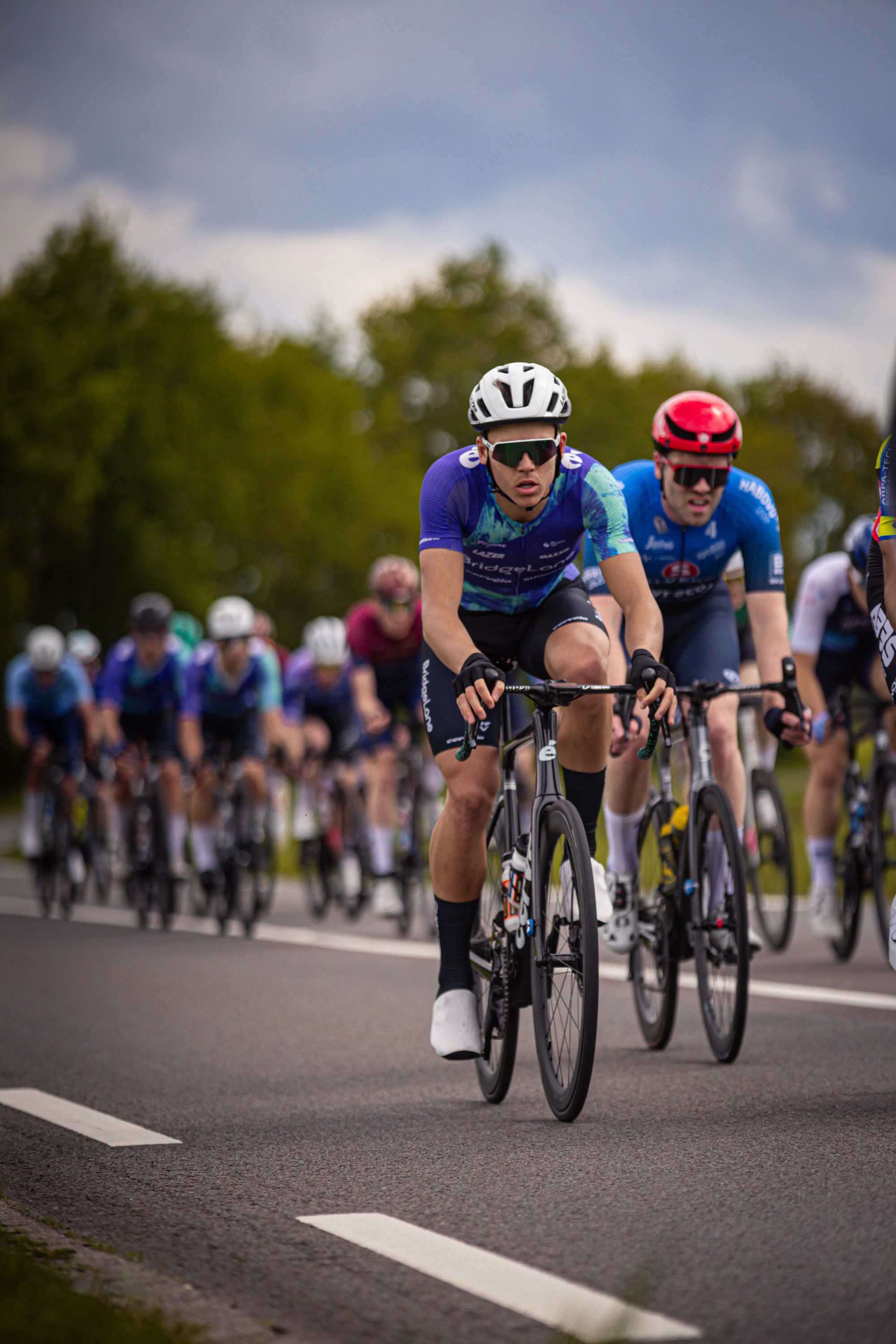 A group of cyclists wearing helmets and riding bikes.