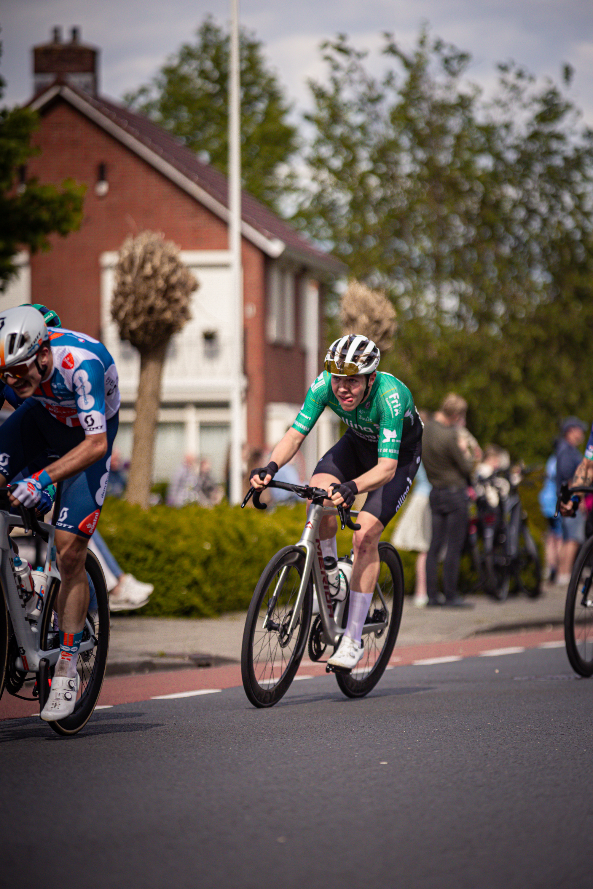 Three cyclists race on a road in Overijssel, Netherlands.