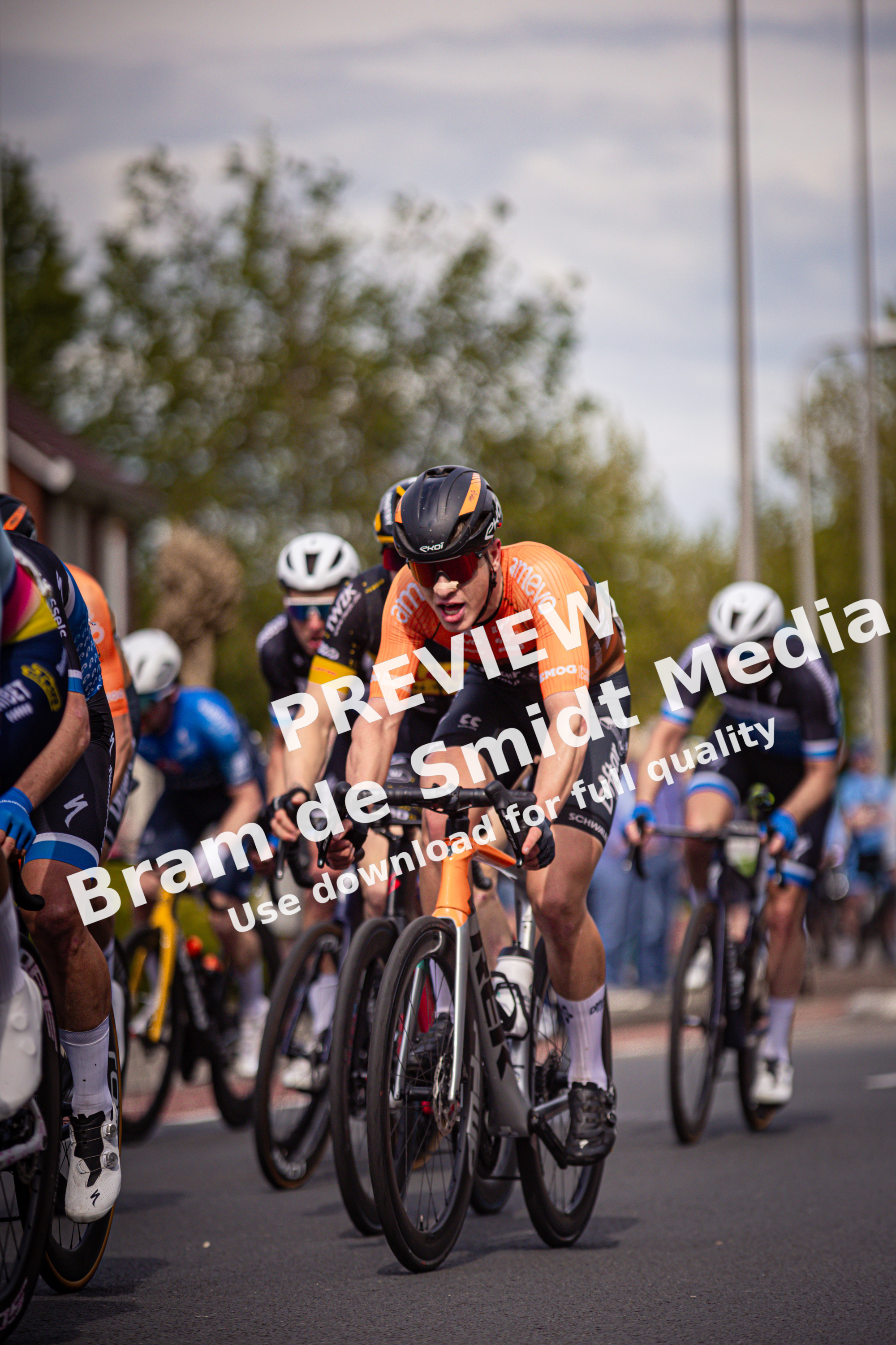 A group of people riding bikes in a race sponsored by the company Wielrennen.