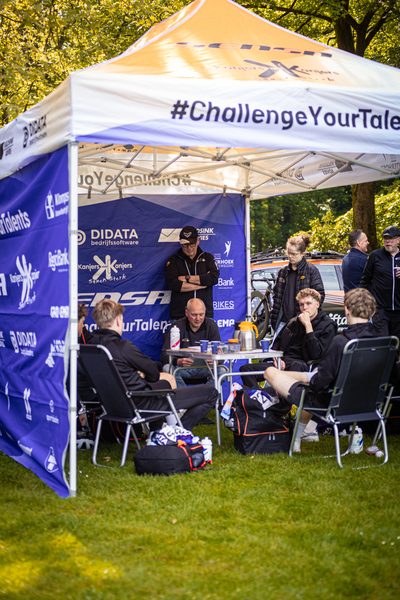 A white tent with a blue banner and orange border that says #ChallengeYourTale.