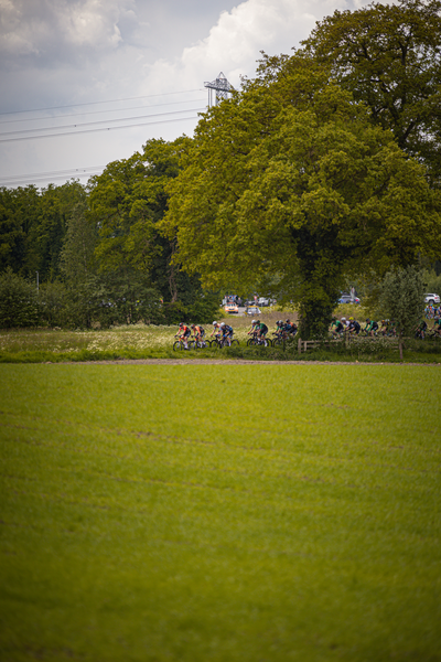 A picture of several people riding bikes in the countryside. It appears to be a cycling event.