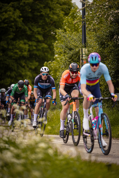 A group of cyclists are riding down a road in the Netherlands during the Rode van Overijssel event.