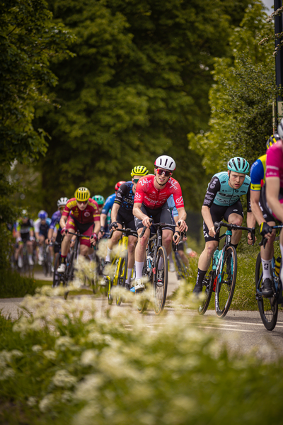 Riders in the Rode van Overijssel bike race wear helmets and jerseys.