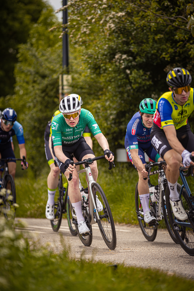 A group of cyclists race down a road during the Ronde van Overijssel cycling event.