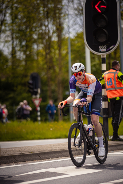 A man in a bicycle race. He is wearing a blue and orange shirt with the number 1 on it.