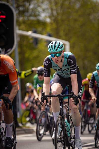 A group of cyclists wearing Wielrennen sportswear are participating in a race.