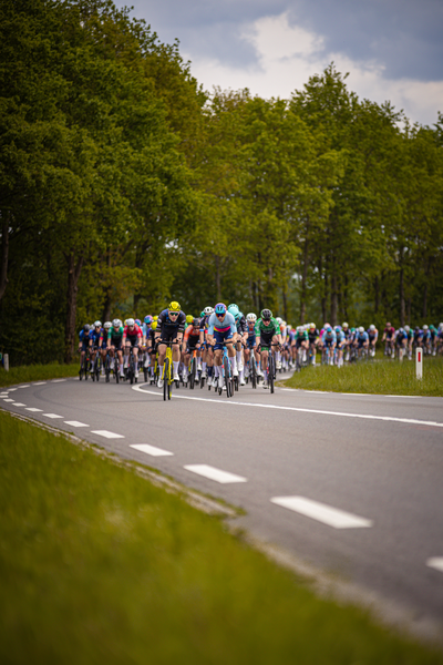 Wielrennen Ronde van Overijssel has a group of cyclists riding down the street.