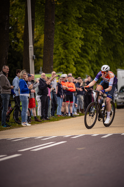 A biker participating in a cycling race with fans watching.