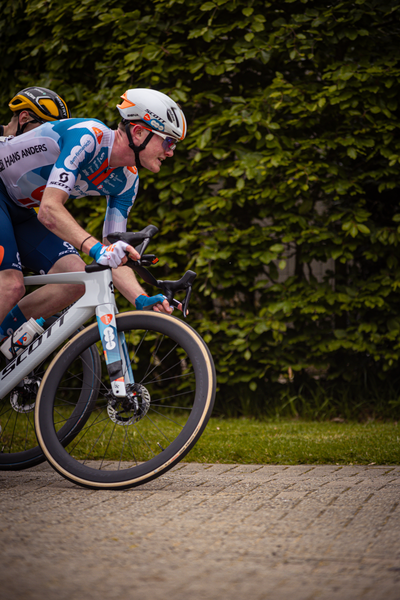 A man riding a bicycle wearing a blue and white striped shirt.