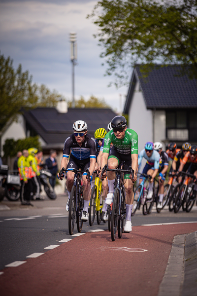 Two cyclists are leading a race down the street in Overijssel, Netherlands.