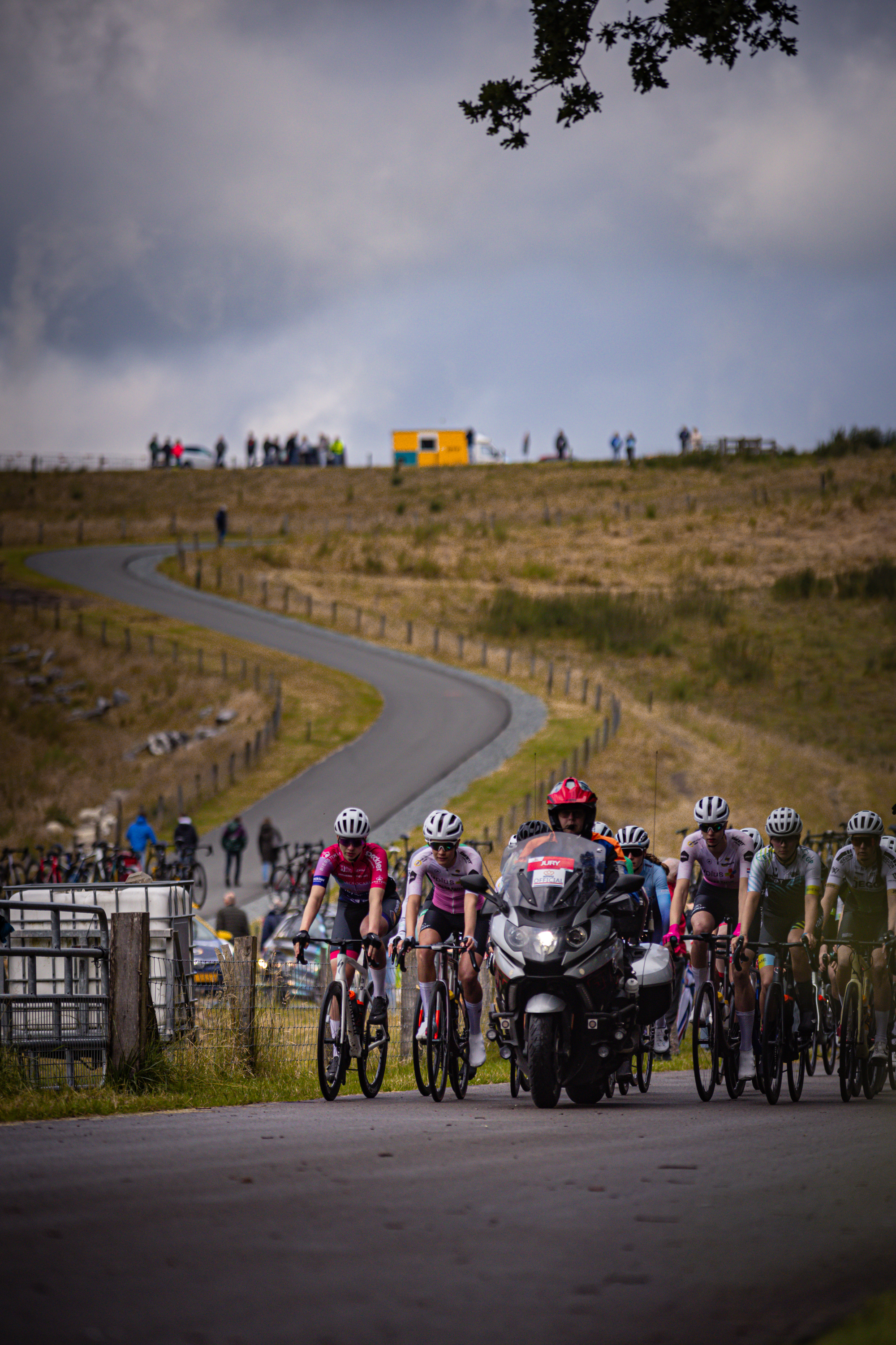 A group of cyclists on a country road with one cyclist wearing the number 1.