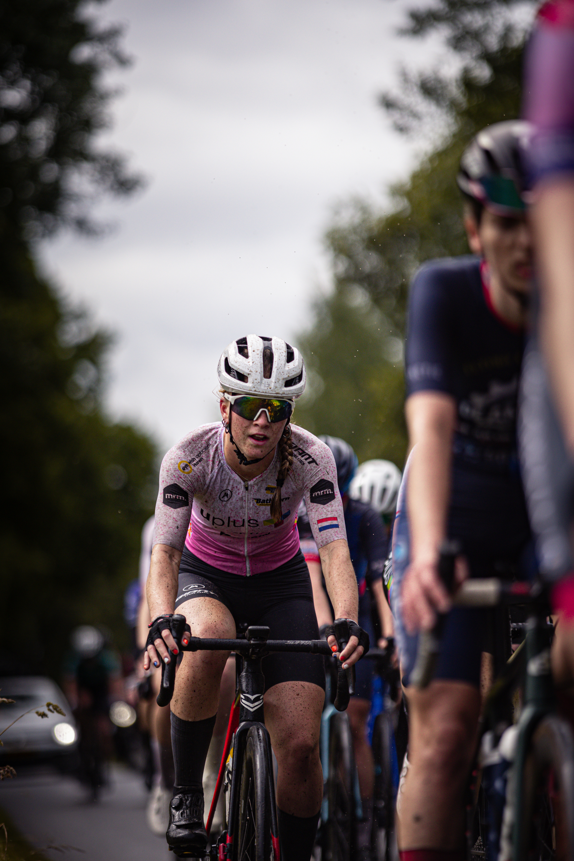 Bicyclists ride together down the road in a race sponsored by Dames Elite ZC.