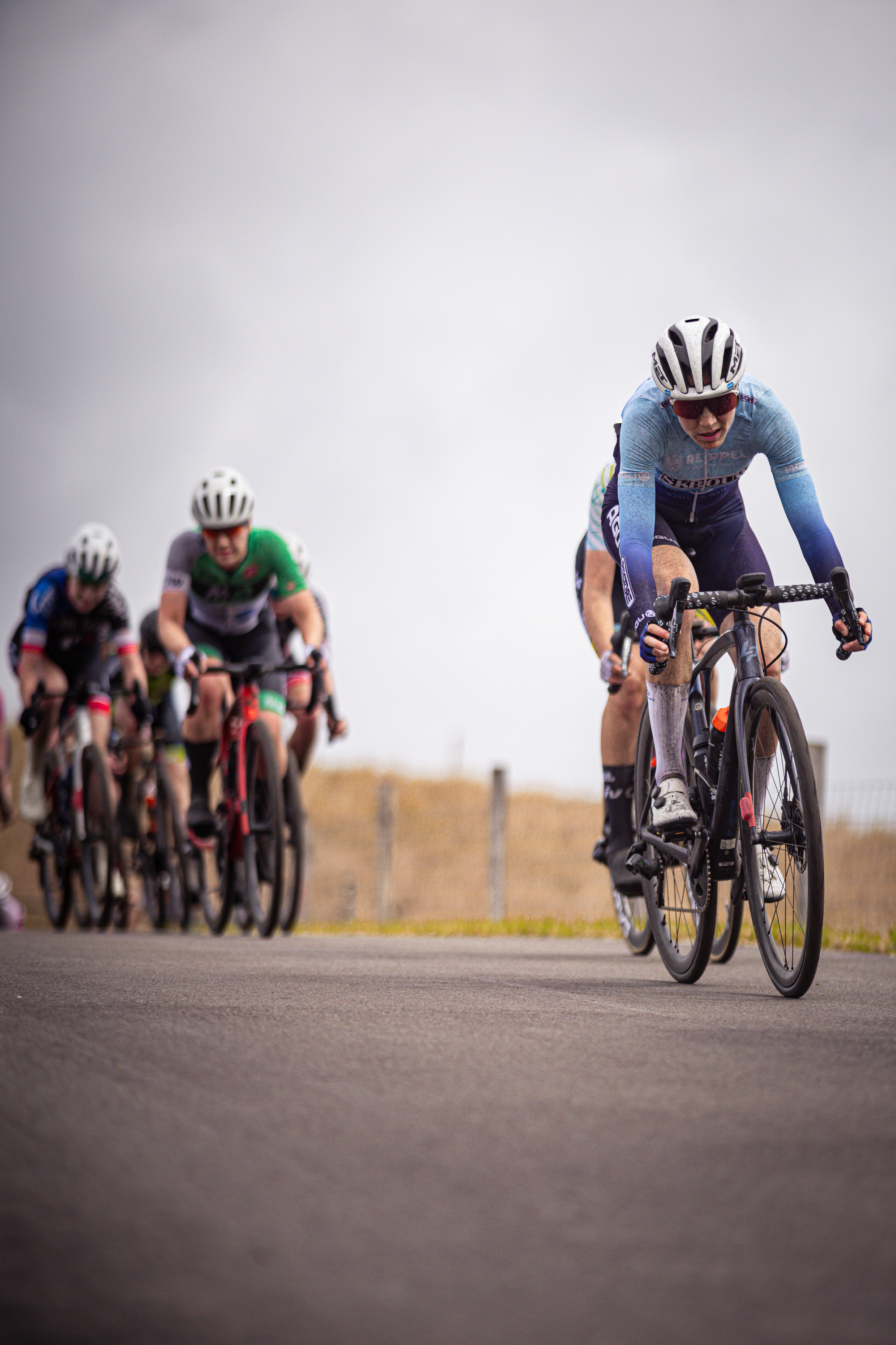 Damen Elite ZC race in the Netherlands. Three cyclists are riding down a road as one wins the 2024 tournament.