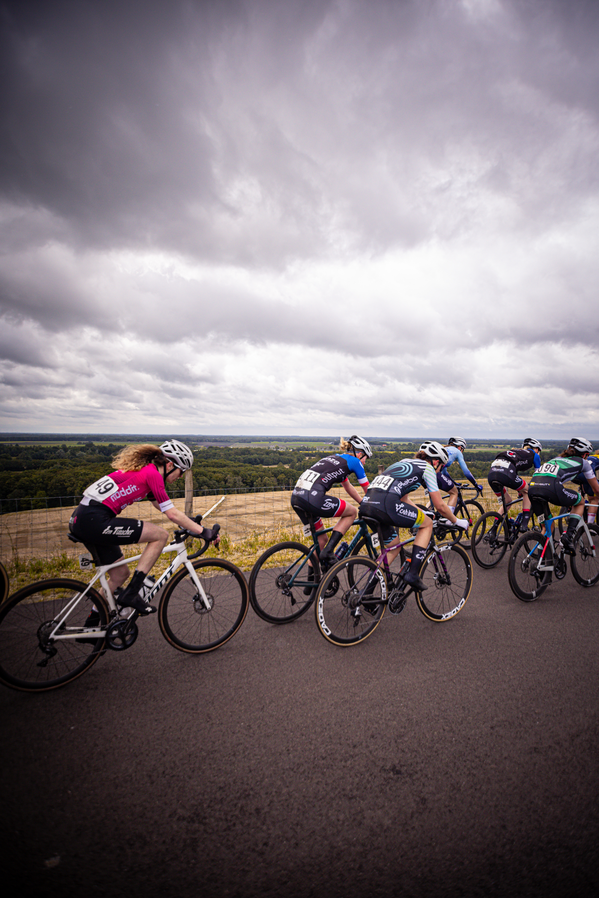 A group of cyclists race down the road during a competition.