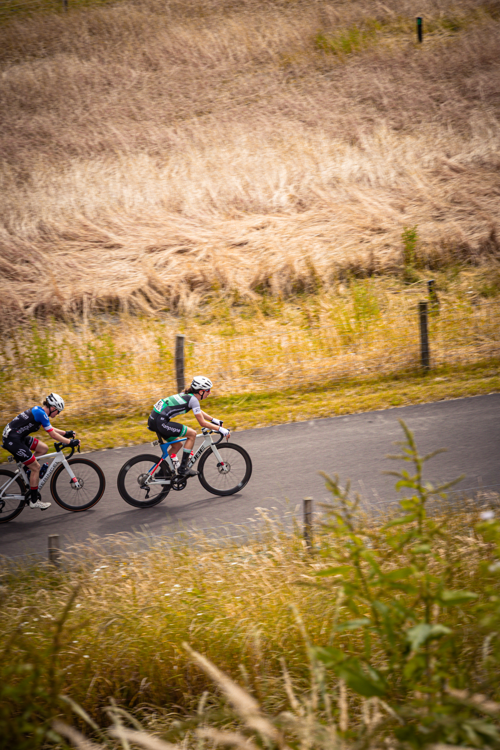 Wielrenners race each other on a road in the Netherlands.