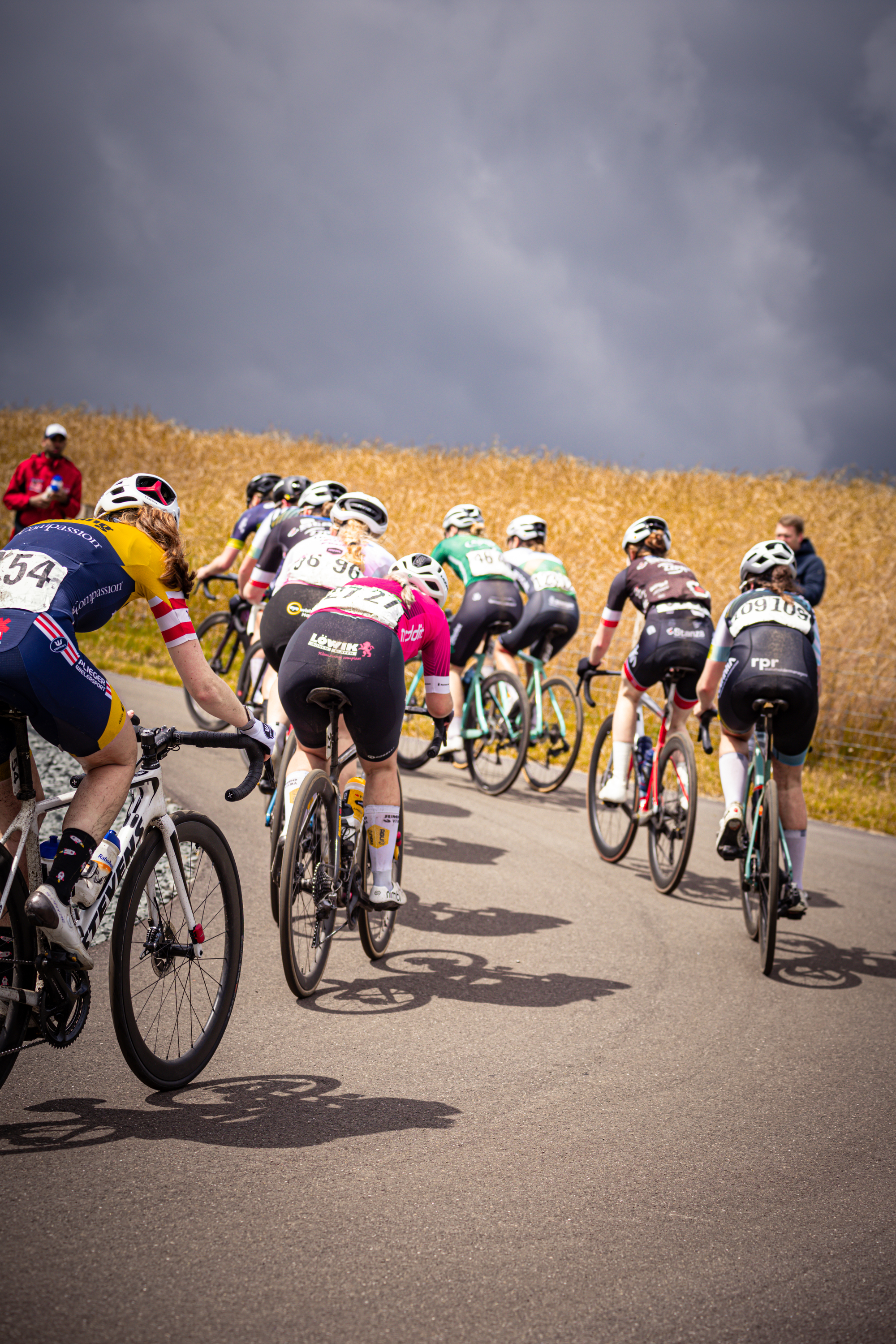 A group of cyclists race down a road with 32 on the front.