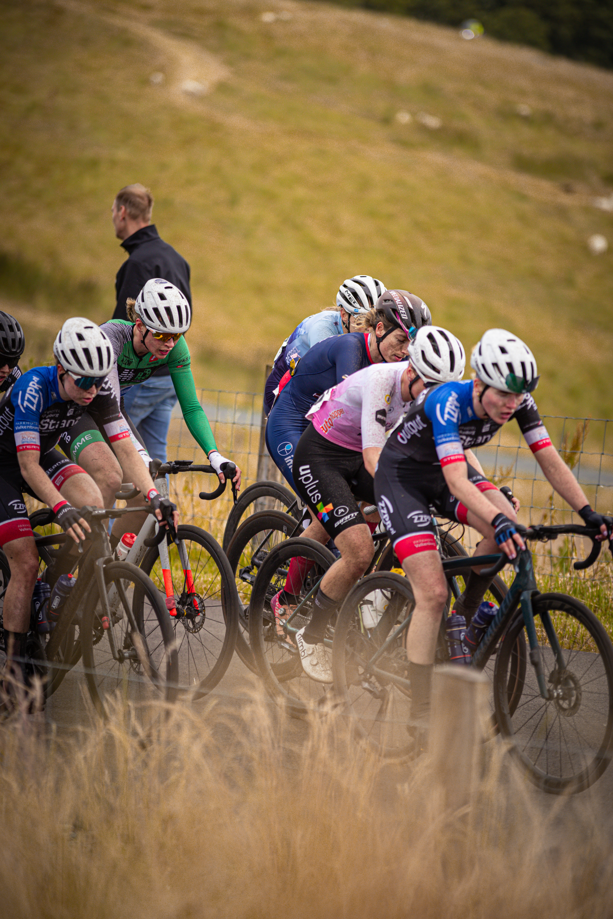 A group of people wearing helmets are riding bikes in a field.