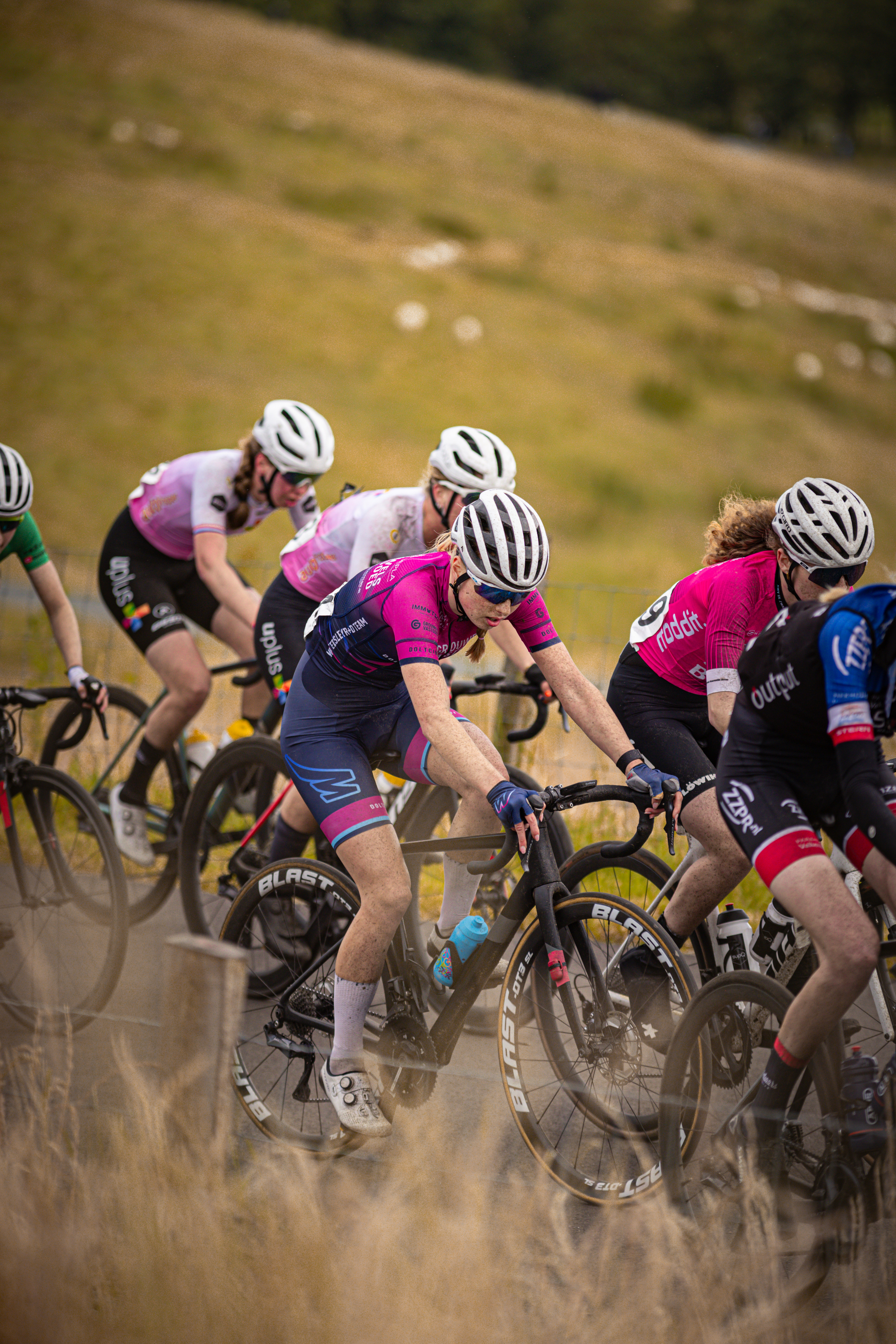 A group of cyclists wearing helmets and riding bikes.