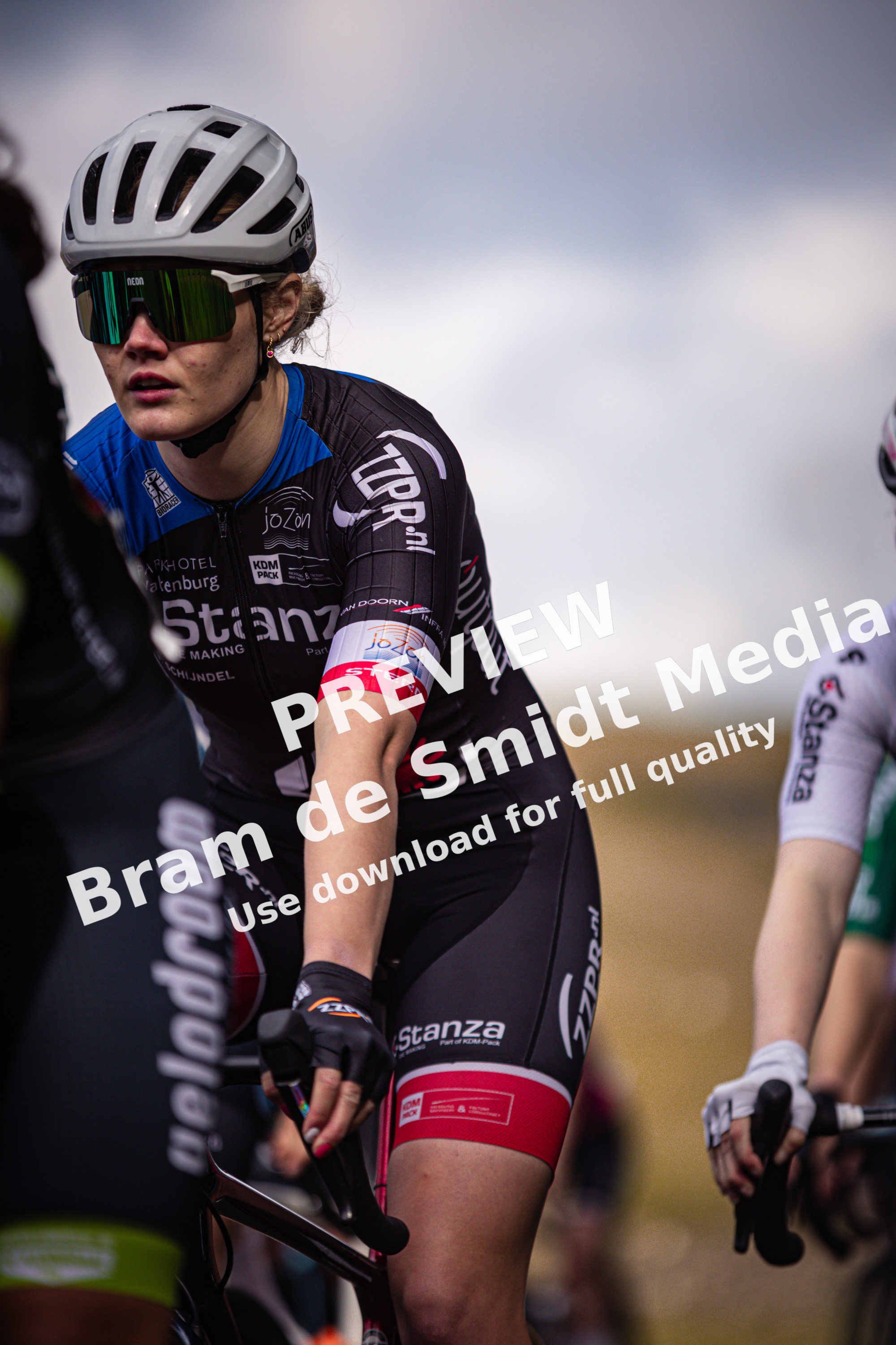 A female cyclist wearing a black jersey with the word "Stanx" on it is riding her bike.