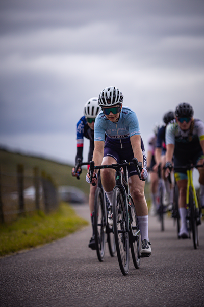 A group of cyclists race down the road as they compete in the Nederlands Kampioenschap.