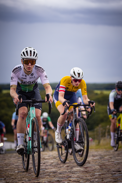 A cyclist in a yellow jersey racing in the Nederlands Kampioenschap.