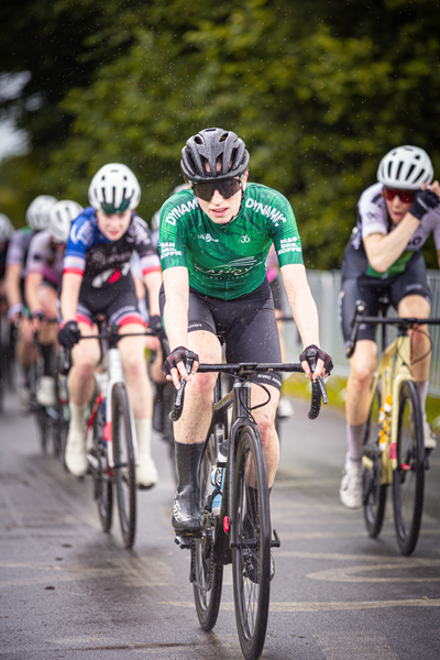 A group of cyclists are participating in the Nederlands Kampioenschap, a cycling event.