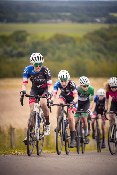 A group of people riding bicycles, one wearing a black shirt with the number 12 on it.