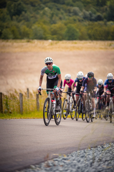 Wielrenners in a group with one man leading on the front.