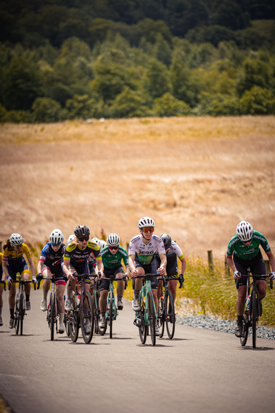 A group of cyclists on a road. One is wearing a number 25 shirt.