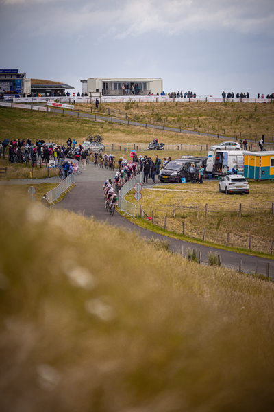 A large group of people are at a gathering, some on bicycles and others on motorcycles.