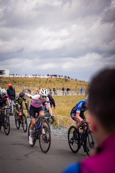 Bicyclists race down a road at the 2024 Nederlands Kampioenschap.