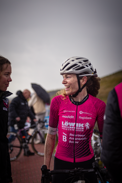 A woman wearing a red bike jersey with the brand Low & Foster on it.