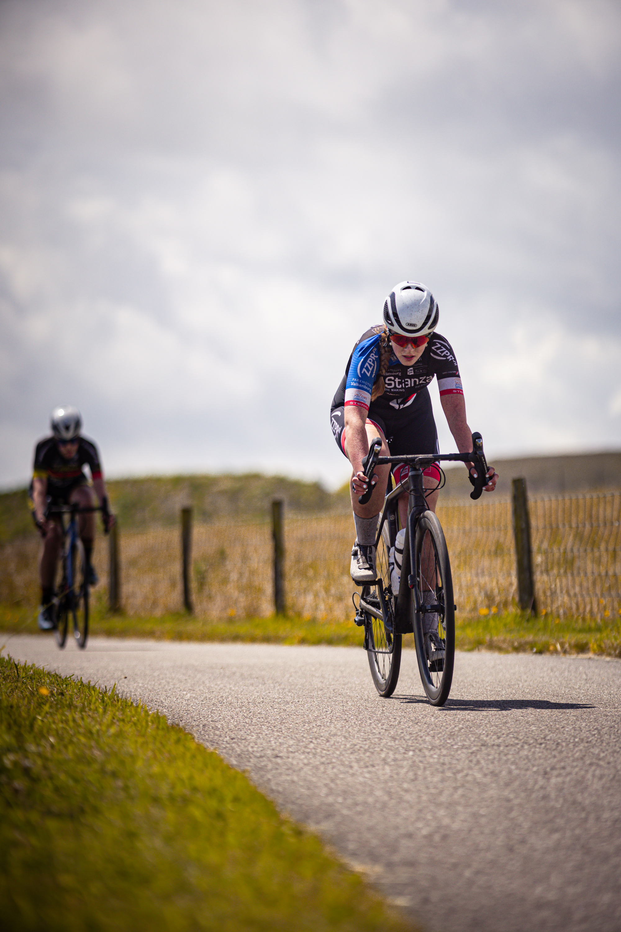 A woman riding a bicycle is wearing the number 44.