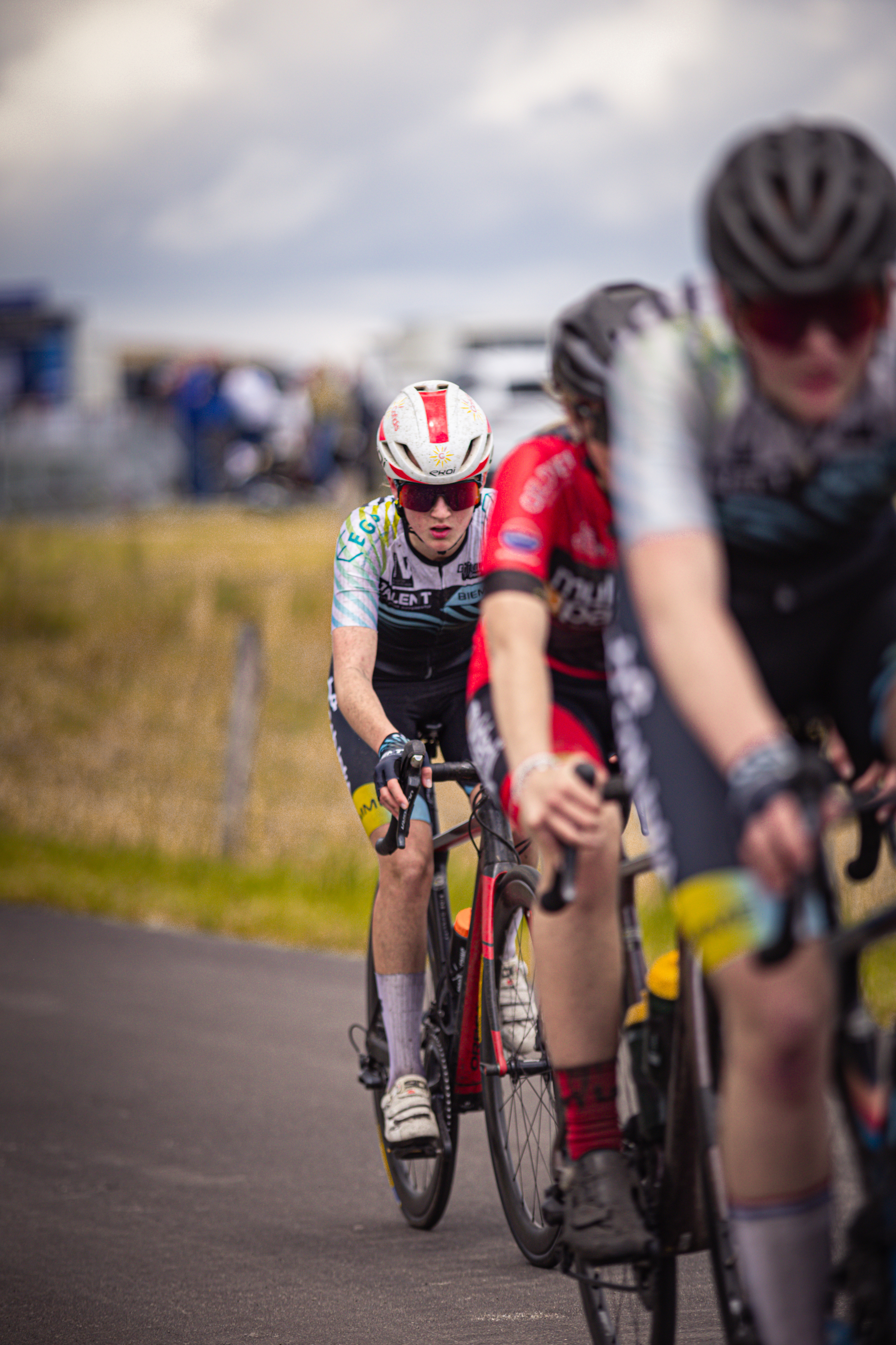 Several cyclists are in a race, all of them wearing helmets.