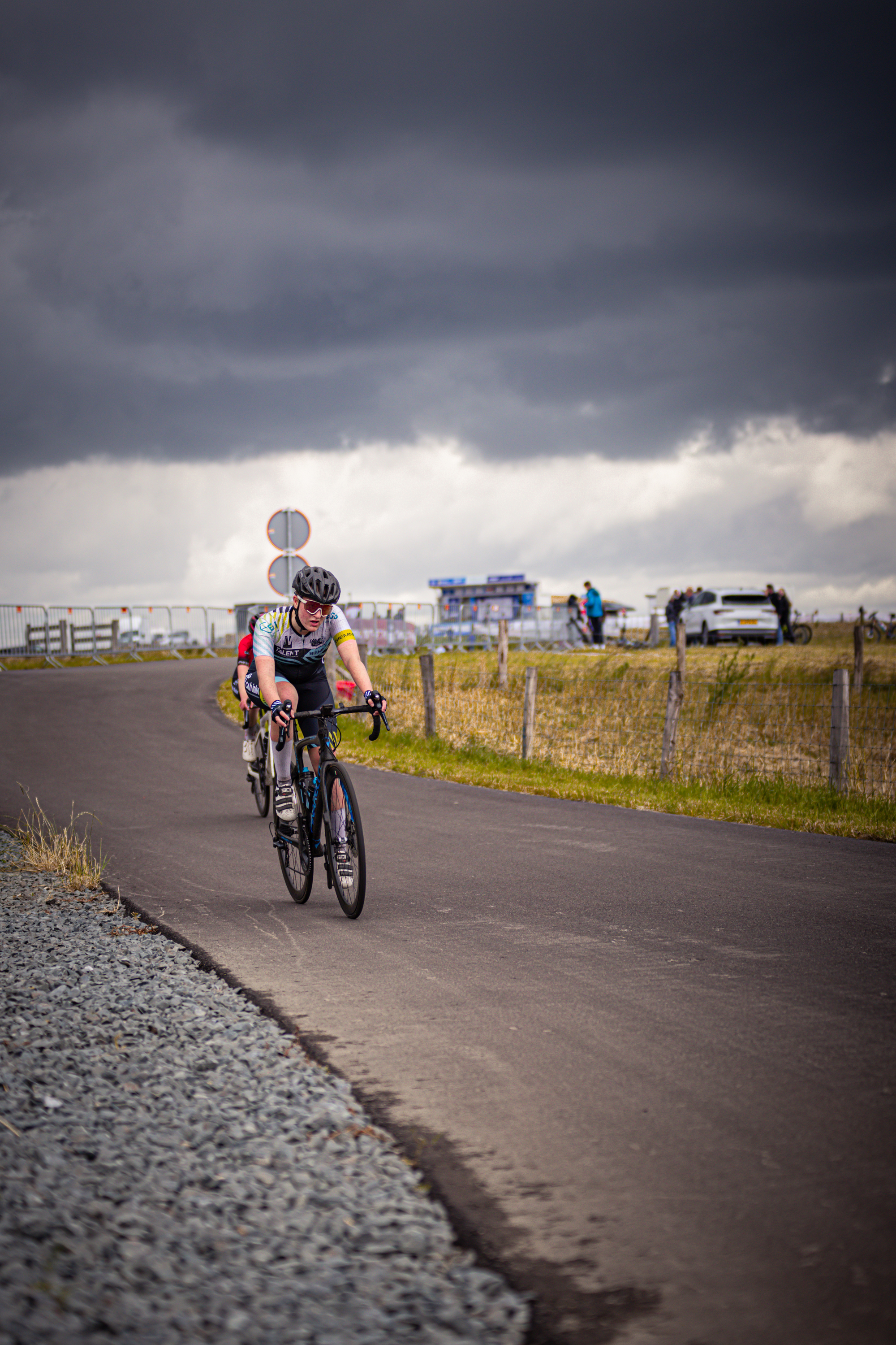 A cyclist is riding down a road during the 2024 Nederlands Kampioenschap.