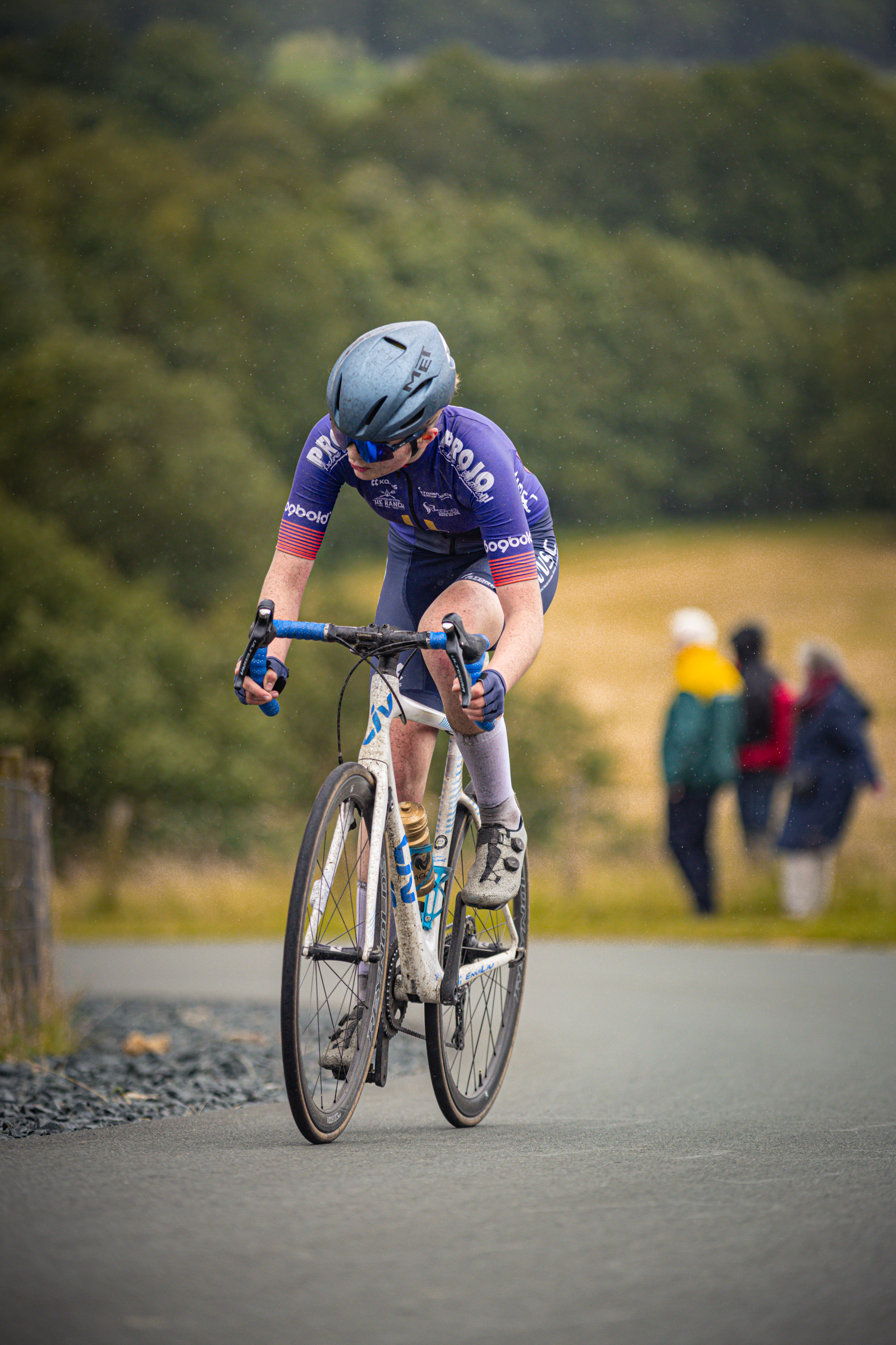 A man wearing a blue helmet riding a bicycle with the word "Bouw" written on his shirt.