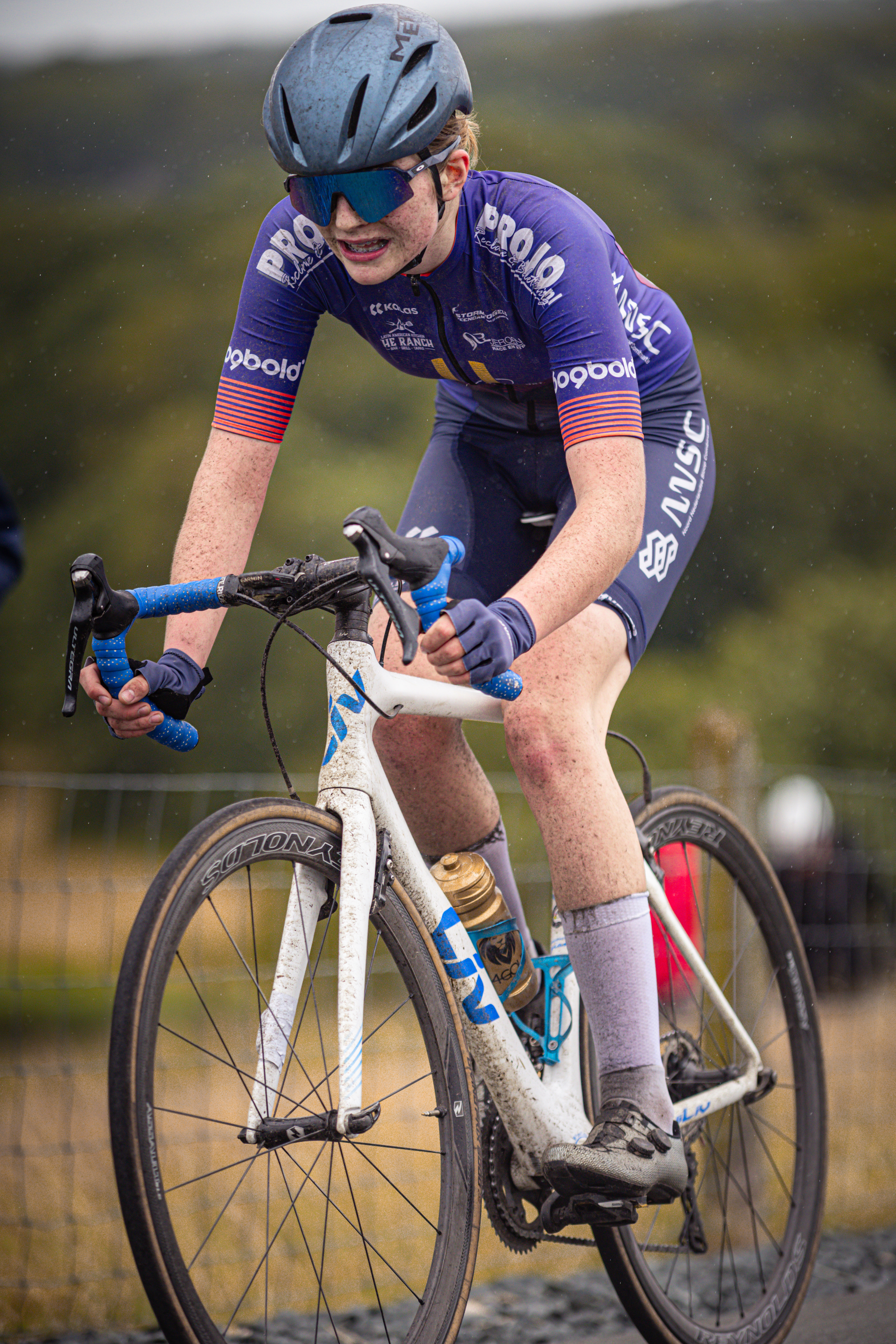 A woman is on a bicycle with the word "nederlands" on her jersey.