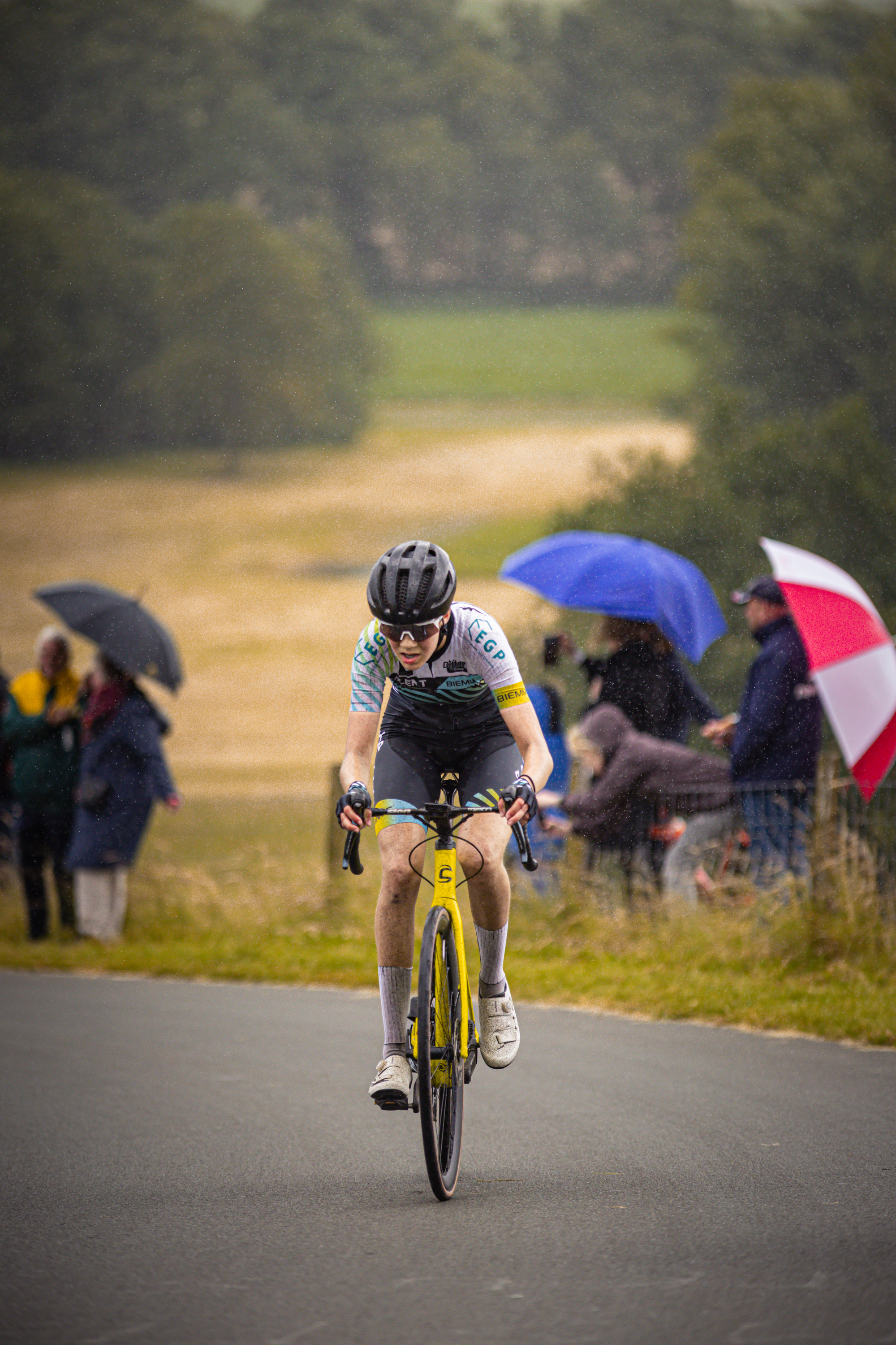 A person wearing a black and blue helmet riding on a bike.