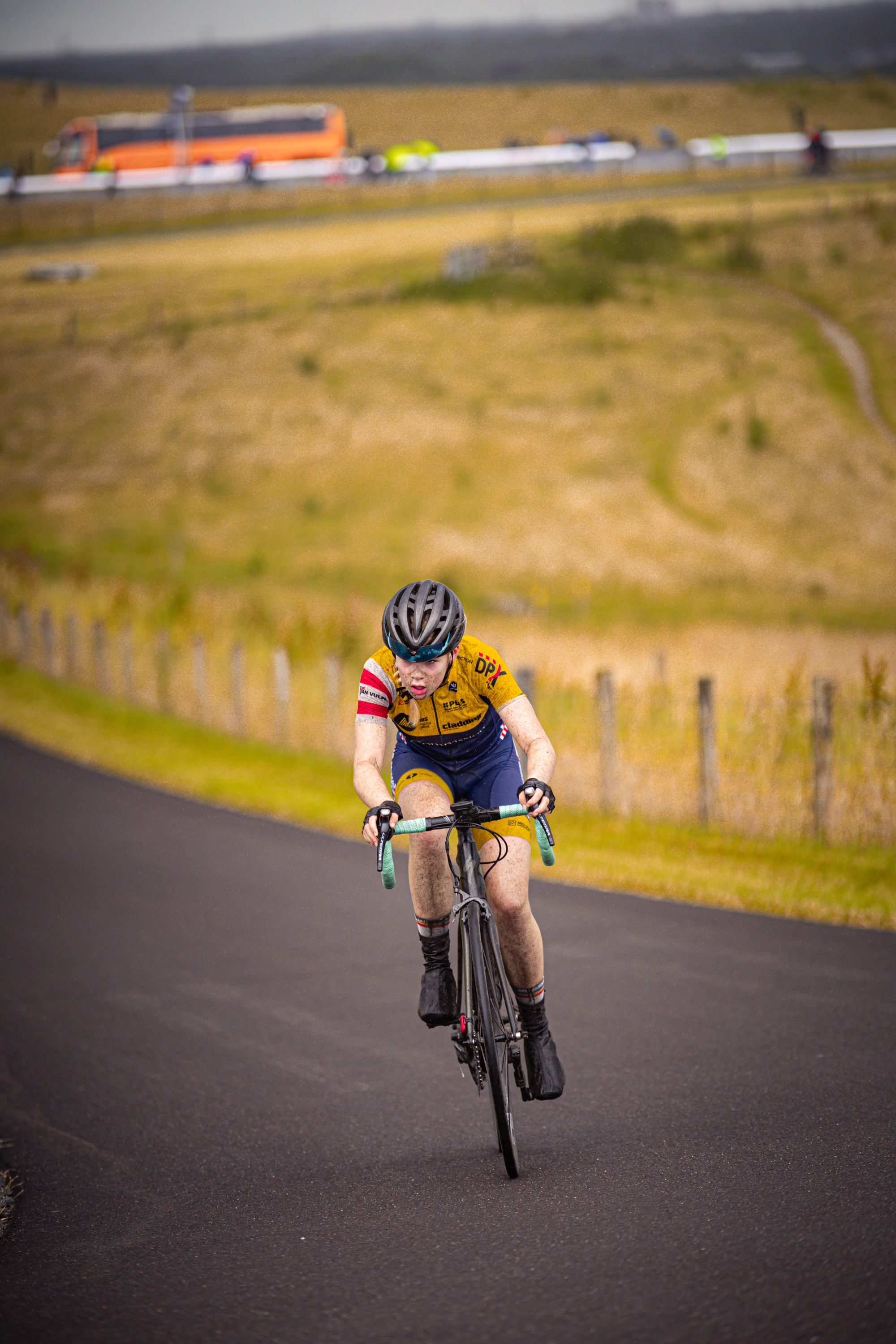 A woman is riding her bicycle on a track during the Nederlands Kampioenschap.