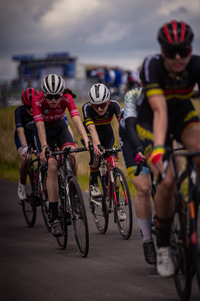 Bicyclists participating in a race, with the man on the far left leading.