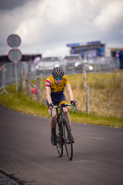 A person on a bicycle participating in the Nederlands Kampioenschap.