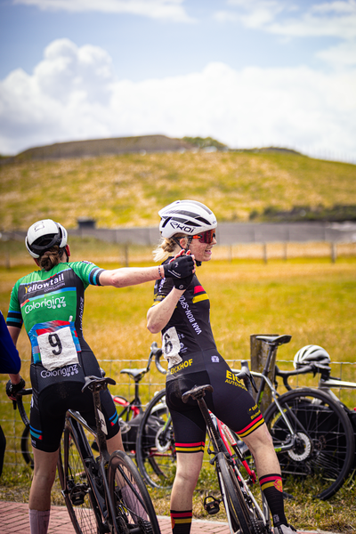 Two cyclists wearing black and yellow are at the 2024 Nederlands Kampioenschap.