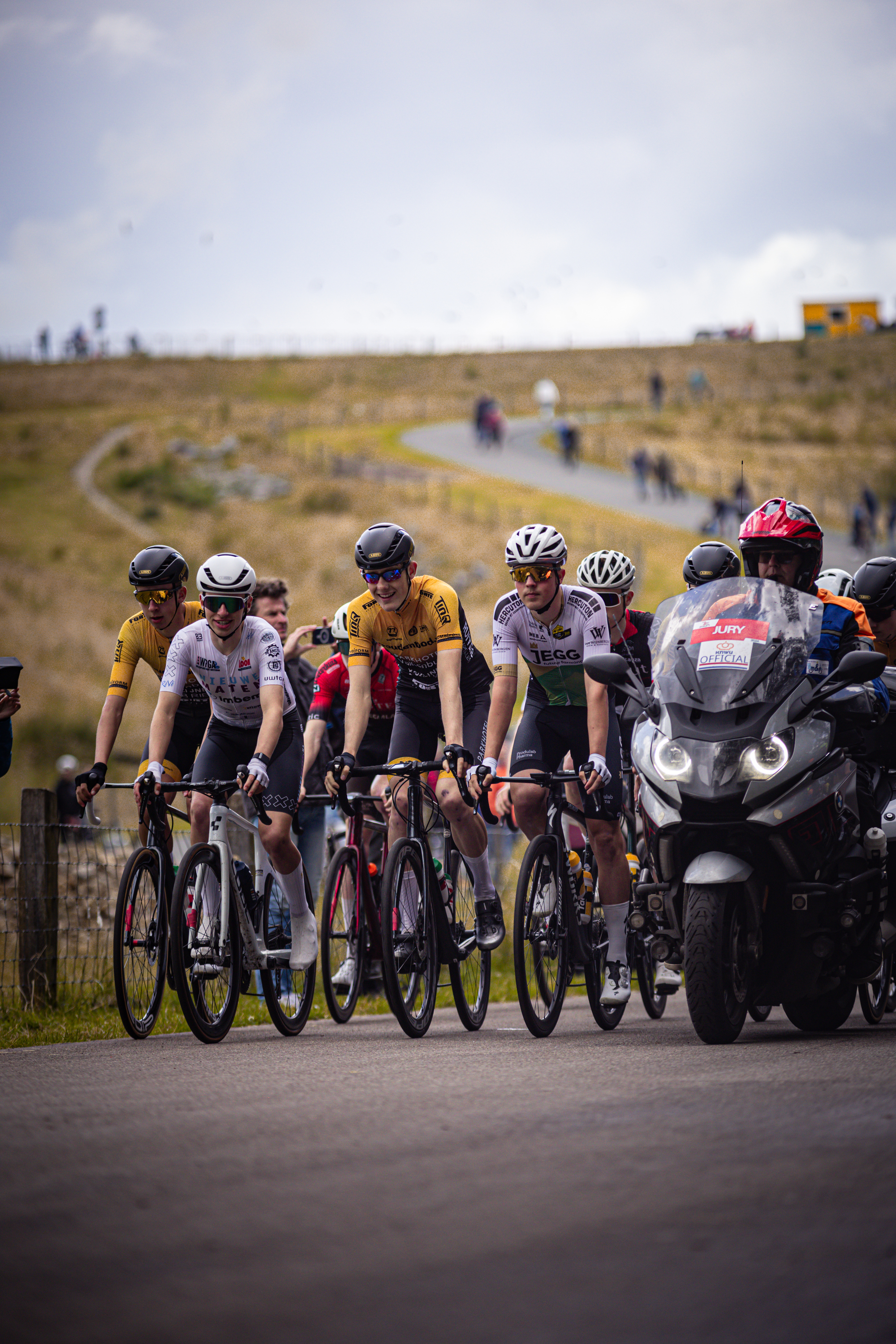 A group of cyclists in a race are lined up and ready to go.